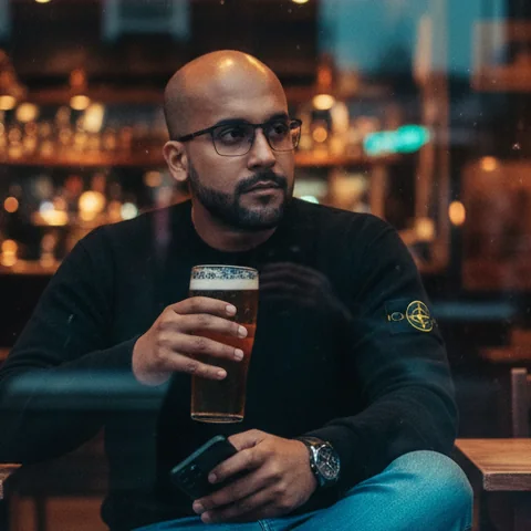 Luis Oses, sentado junto al ventanal de un bar al atardecer.